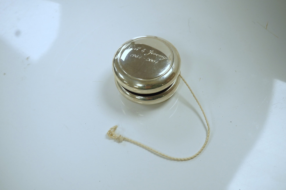 A modern silver mounted yo-yo, Practical Silverware, London, 2003, 56mm, with engraved inscription. Condition - fair to good